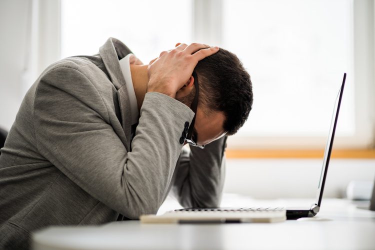 Acute Stress, stressed out man at desk with head down - stress and recovery