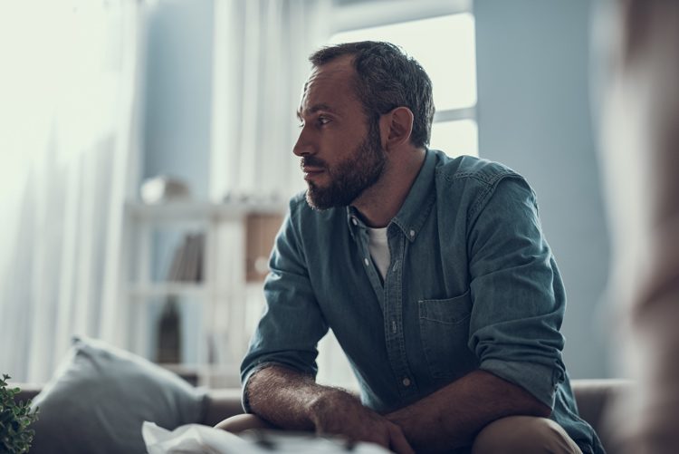 man sitting at home looking thoughtful - relapse