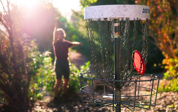 man playing disc golf at park - exercise