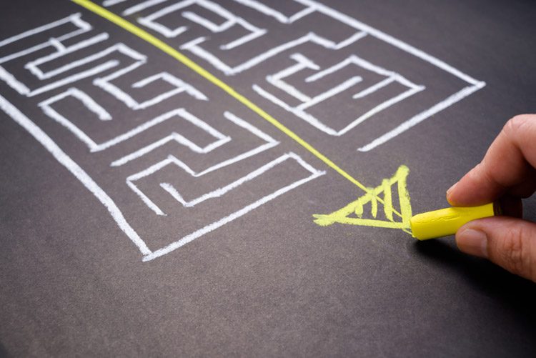 maze drawn in white chalk on blackboard with a yellow arrow drawn down the middle - recovery goals