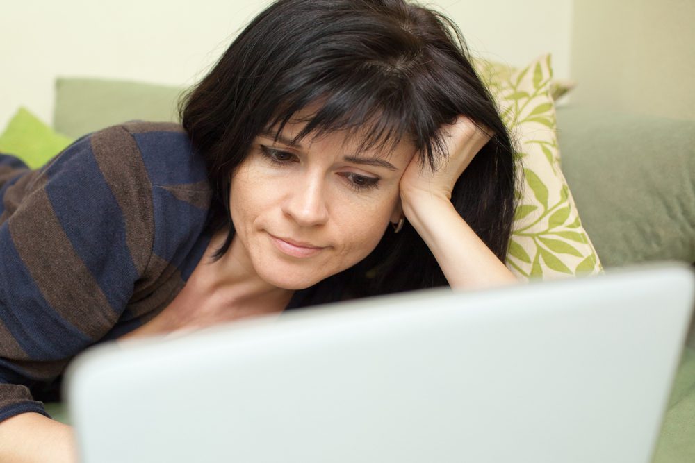 woman reading blog articles on her laptop