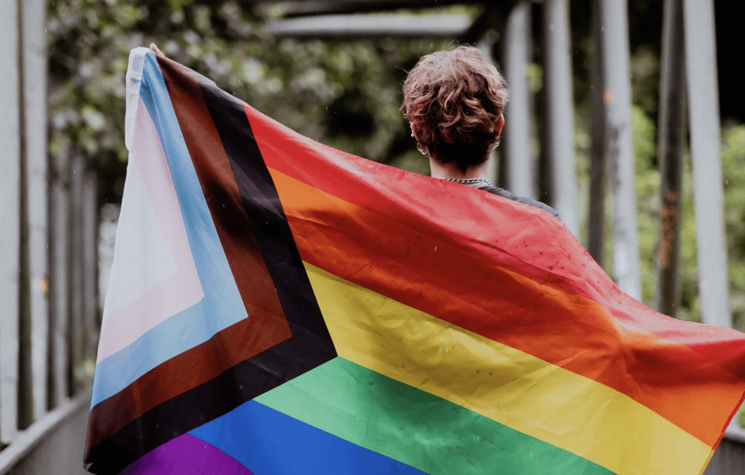 A person carrying a pride flag.