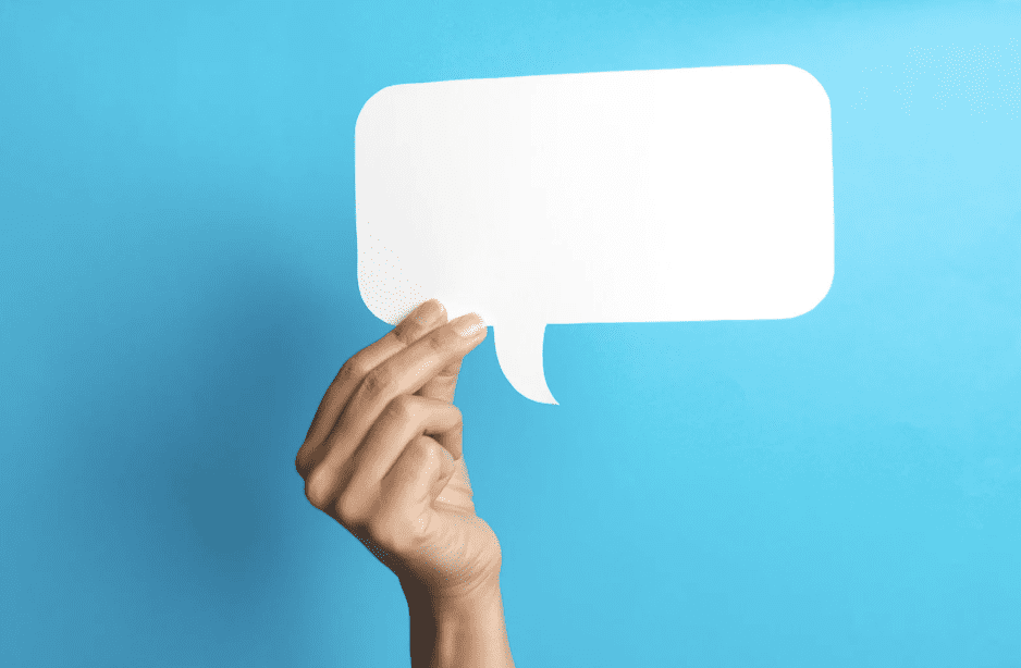 A hand holding up a blank speech bubble.
